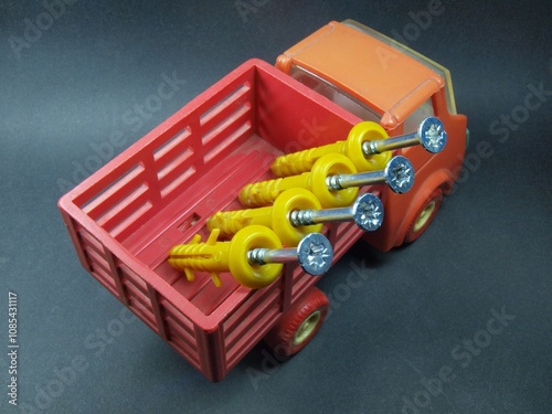 Toy truck. Delivery of building materials. Dowel, screw and self-tapping screw. Accessories and fasteners