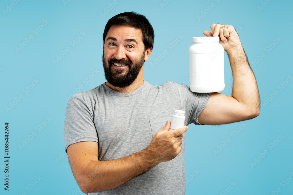 Happy man showing supplements and protein on blue background Happy man showing supplements and protein on blue background