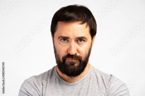 Serious bearded man looking directly at camera on white background photo