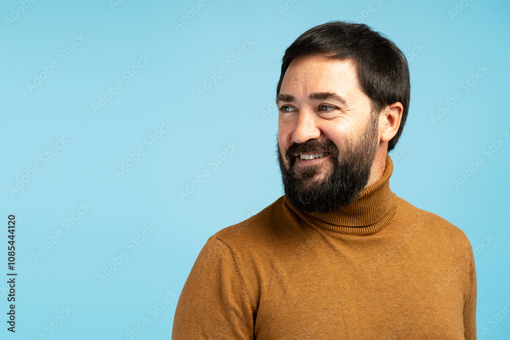 Smiling bearded man looking away on blue background Smiling bearded man looking away on blue background