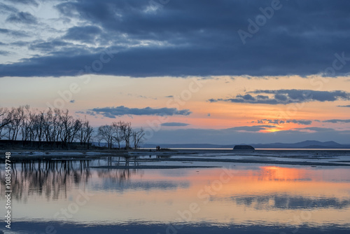  Winter landscape. The surface of the ice is bound by ice, with a perfectly smooth, mirror-like appearance. Sunset in winter over the lake.  photo