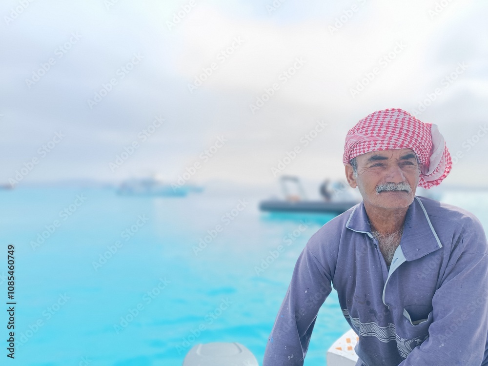 Fototapeta premium an old sailor with a white mustache who is a retired soldier in the navy wearing a Bedouin scarf on his head