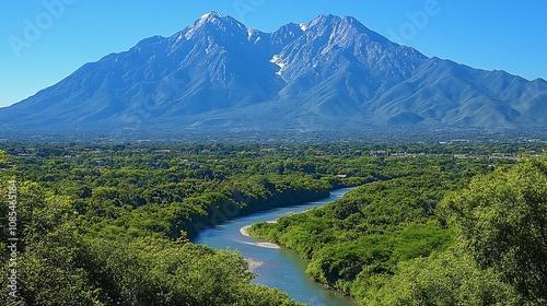 A winding river flows through a valley, with a majestic mountain range in the background. The lush greenery creates a serene and beautiful landscape.