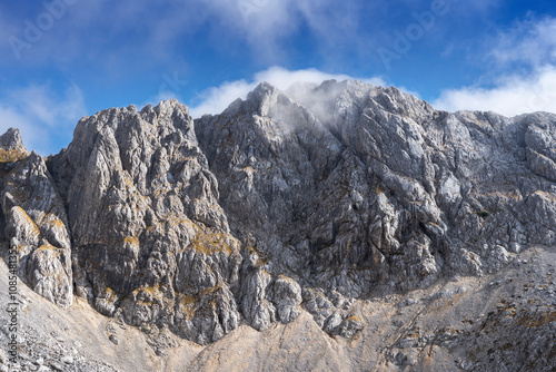 a huge mountain range showing the vastness of the mountains. The peak is covered with clouds like the Himalayas. You can also see rocks as a result of mountain avalanches.