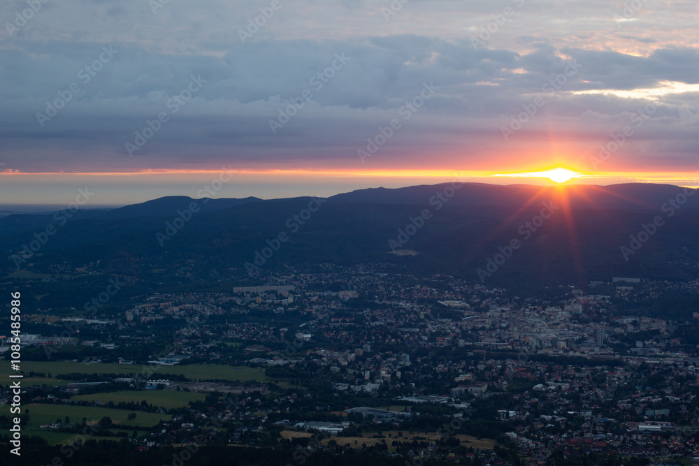 Obraz premium dawn against the backdrop of mountains and a small town