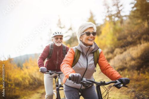 Obraz na płótnie A senior couple enjoys a leisurely bike ride through the vibrant colors of autumn, basking in the warm sunshine and the joy of companionship. w salonie