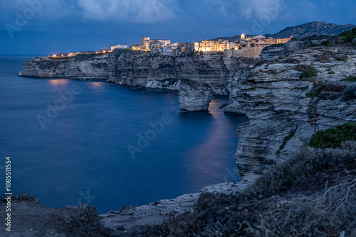 Die Beleuchtung von Bonifacio spiegelt sich im Meer, Langzeitbelichtung von Bonifacio in Korsika zur blauen Stunde
 photo