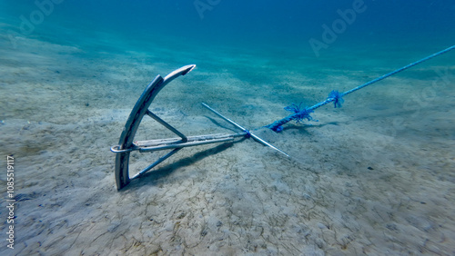 Anchor on the seabed. A metal anchor lies on the sandy seabed, buried in the ground. photo