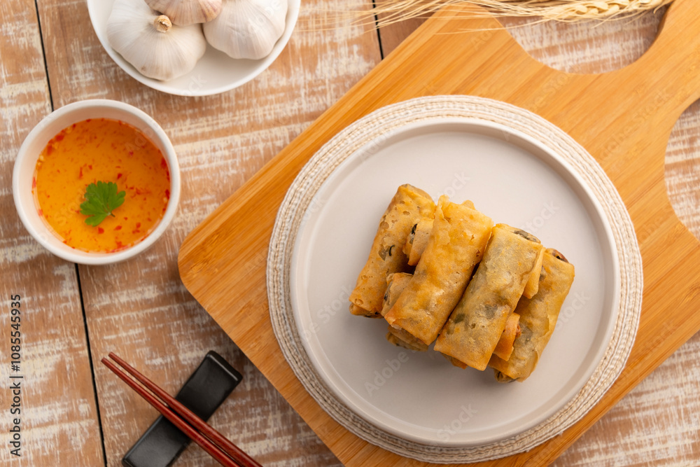 egg rolls,Deep fried Chinese Chives Spring Rolls(Gui Chai) on a white plate.Thai snack food.Top view. egg rolls,Deep fried Chinese Chives Spring Rolls(Gui Chai) on a white plate.Thai snack food.Top view.