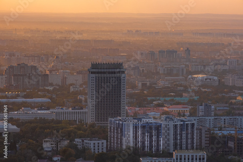 Beautiful sunset over Almaty city, bright colors of sunset sky in autumn in the city. Recognizable buildings of the city, symbols of Almaty at sunset