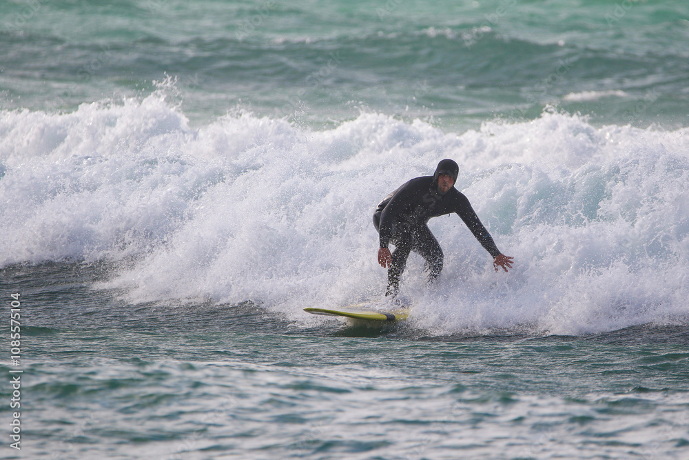surfer in a wetsuit on a board glides through the waves in a strong wind surfer in a wetsuit on a board glides through the waves in a strong wind