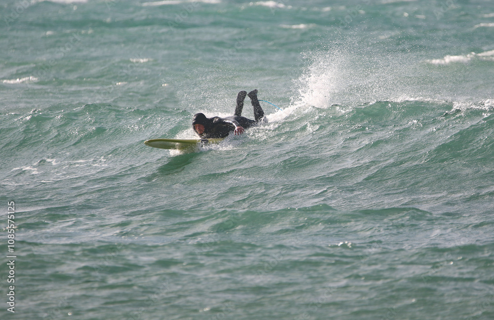 surfer in a wetsuit on a board glides through the waves in a strong wind