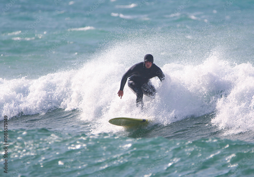 surfer in a wetsuit on a board glides through the waves in a strong wind surfer in a wetsuit on a board glides through the waves in a strong wind