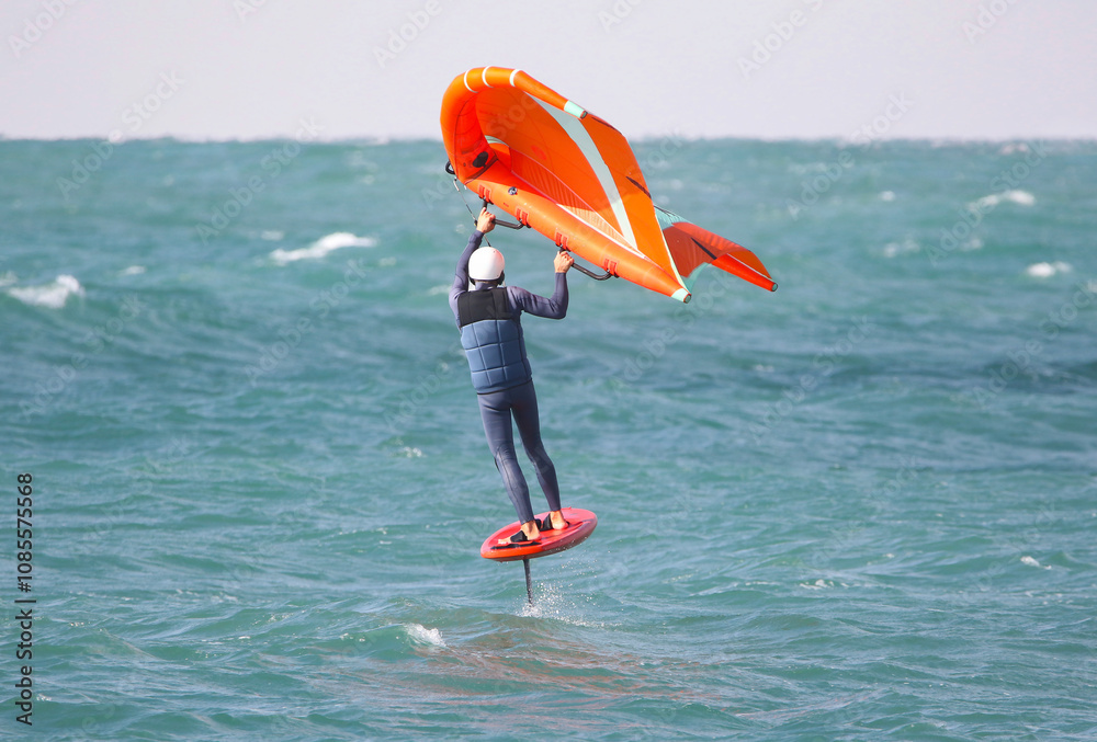 wing surfer glides gracefully on the surface of a raging sea