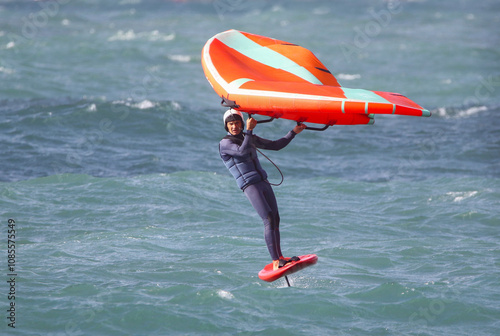 Obraz na płótnie wing surfer glides gracefully on the surface of a raging sea w salonie