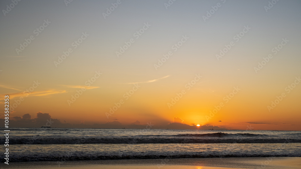 A beach view at sunset with clouds creating a dramatic yet calm atmosphere, evoking the beauty and serenity of a summer evening by the ocean. A beach view at sunset with clouds creating a dramatic yet calm atmosphere, evoking the beauty and serenity of a summer evening by the ocean.