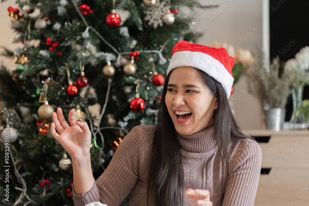 Young Woman Joyfully Decorating Her Room for Christmas with Festive Ornaments and a Beautifully Lit Christmas Tree