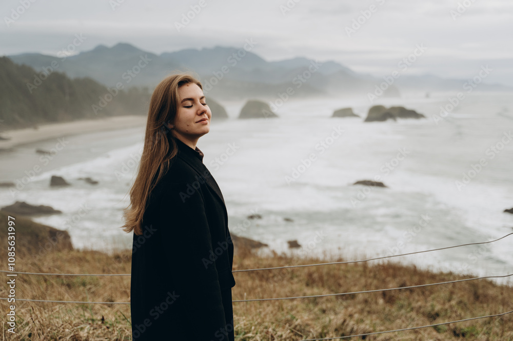 A beautiful girl in black clothes is spending time on the beach by the ocean. A beautiful girl in black clothes is spending time on the beach by the ocean.