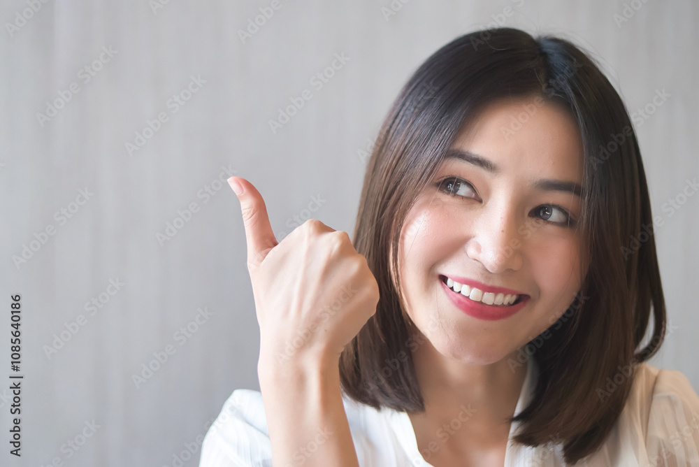 Asian Woman giving approving thumb up for yes, alright, ok, positive, OK for all correct gesture Asian Woman giving approving thumb up for yes, alright, ok, positive, OK for all correct gesture