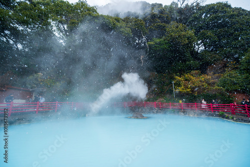 Beppu, Japan - December 21, 2023: Tourist take photo Cobalt blue hell pond of Kamado Jigoku, Japanese hot springs is the famous natural hot springs in Beppu, Japan photo