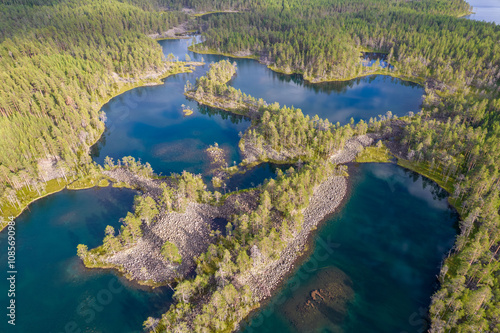 Lakes with rocky shores in the middle of a forest is a typical glacial landscape of the Republic of Karelia, northwest Russia. Uksinsky esker ridge. Aerial view