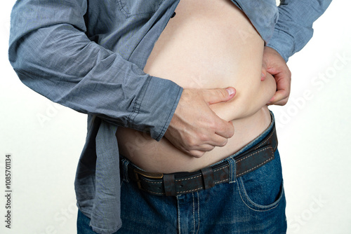 Fat man touching his fat belly at leaving home. overweight fat belly. Diet lifestyle, stomach muscle, Fat and Health concept. photo