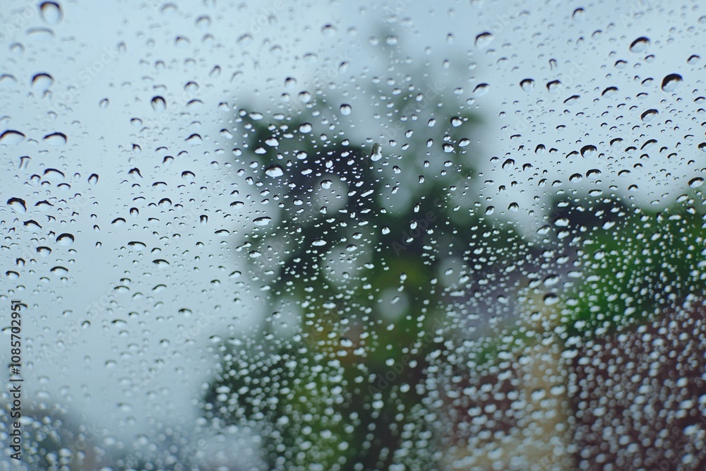 Raindrops on wet windows surface background image. Water droplets on the glass on a natural background. Raindrops on wet windows surface background image. Water droplets on the glass on a natural background.