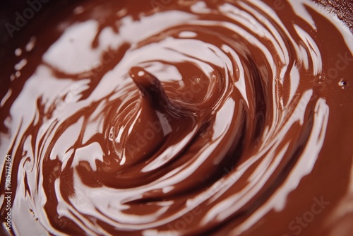 Melted dark chocolate pouring and mixing into a bowl, creating beautiful swirls