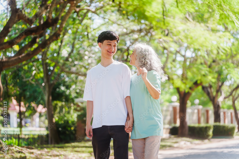 Young son and his mature mom asian people share loving hug in beautiful park, surrounded by nature. Their happiness radiates as they bond outdoors, celebrating family love and togetherness. Young son and his mature mom asian people share loving hug in beautiful park, surrounded by nature. Their happiness radiates as they bond outdoors, celebrating family love and togetherness.