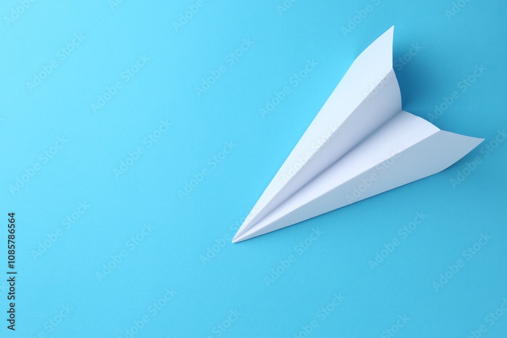 Naklejka premium One handmade paper plane on light blue background, top view. Space for text