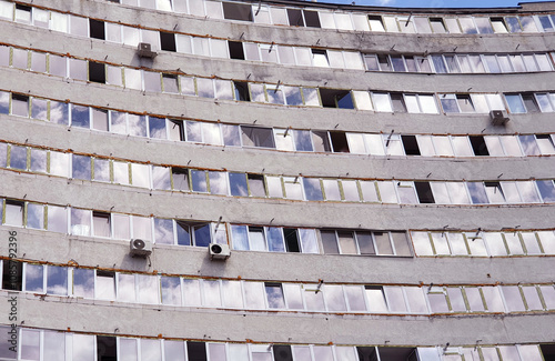 Renovation of block of flats, building with new windows. Apartment block destroyed and rebuilt.. building under repair. air conditioners in a huge building photo