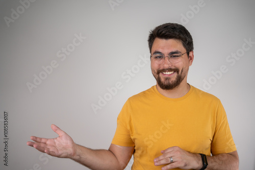 Portrait of cheerful businessman pointing at copy space for advertising against grey background