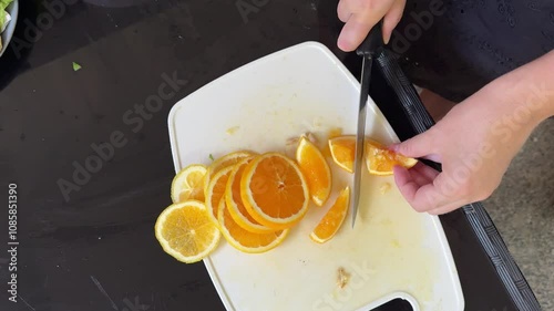 Woman cutting orange for lemonade, top view