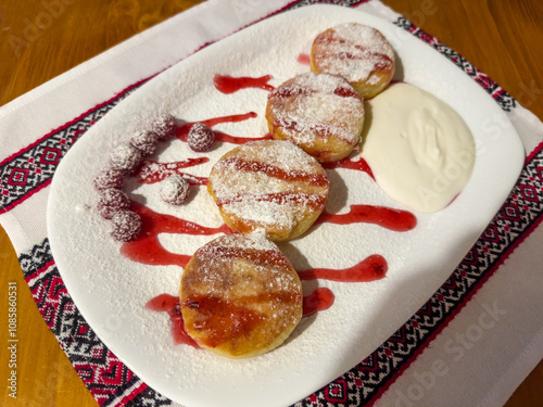 Сottage cheese pancakes serving with sour cream and raspberry jam photo