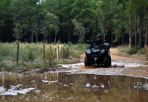 Offroad with an ATV in the forest, mud and puddles after the rain