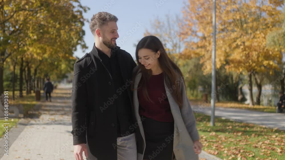 Couple enjoying a romantic autumn walk through the park Couple enjoying a romantic autumn walk through the park