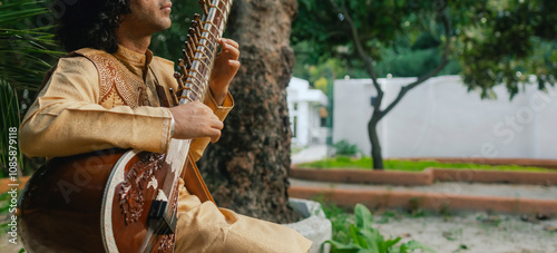 Photography Indian musician in traditional clothes playing sitar festive season outdoor home