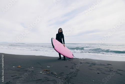 Photography Surfer happy woman in wetsuit with surfboard go to winter surfing in Atlantic ocean