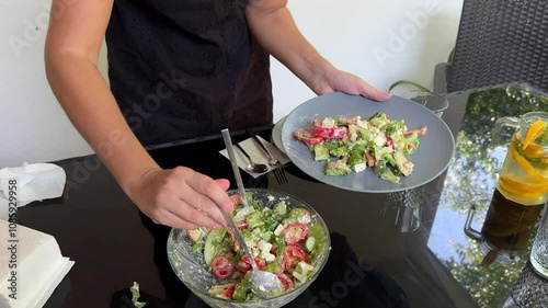 Woman cutting orange for lemonade, preparing healthy salad and serving table 