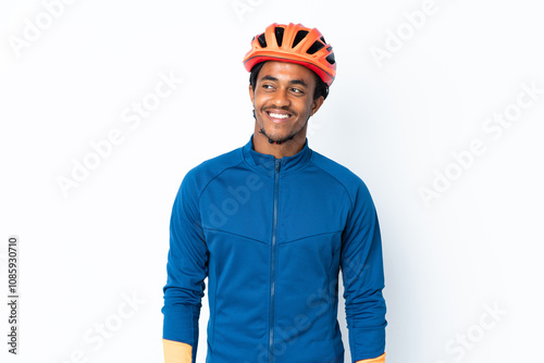 Young cyclist man with braids over isolated background thinking an idea while looking up photo