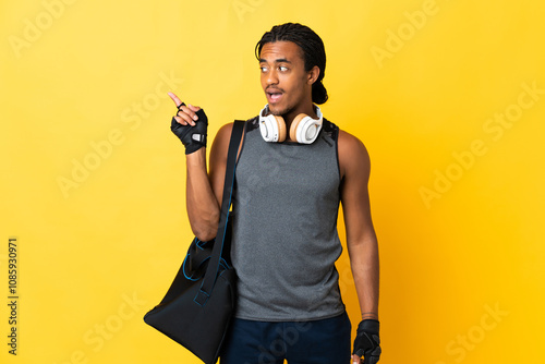 Young sport African American man with braids with bag isolated on yellow background intending to realizes the solution while lifting a finger up