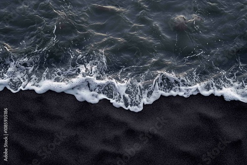 Drone aerial view of the sea or ocean waves splashing on a dark navy blue or gray sand beach with beautiful transparent clear water
 photo