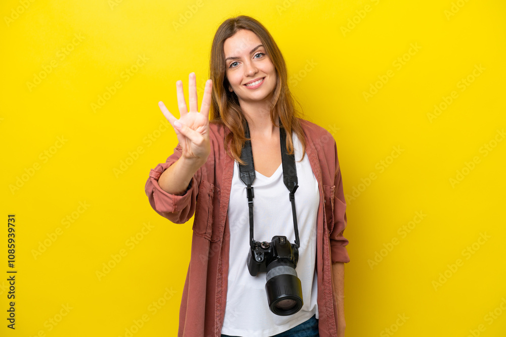 Young photographer caucasian woman isolated on yellow background happy and counting four with fingers Young photographer caucasian woman isolated on yellow background happy and counting four with fingers