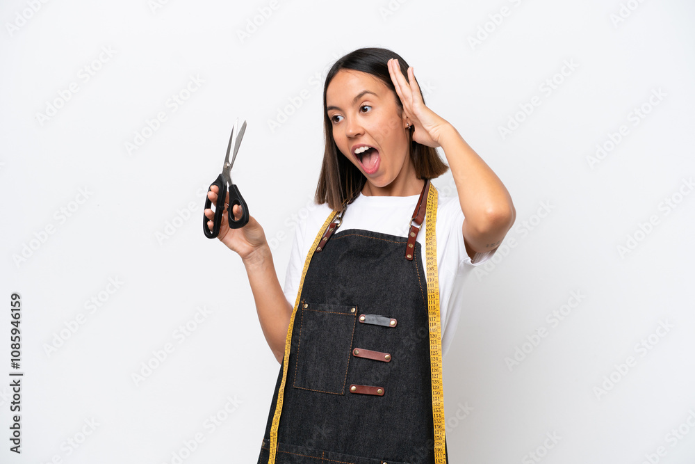 Young seamstress woman isolated on white background doing surprise gesture while looking to the side Young seamstress woman isolated on white background doing surprise gesture while looking to the side