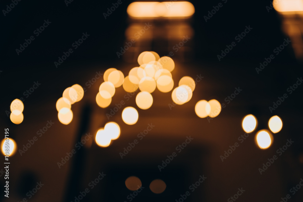 Fototapeta premium Decorative string lights at night time, Defocused Background, night city backdrop, party time with Yellow bokeh balls. Abstract blurred warm light
