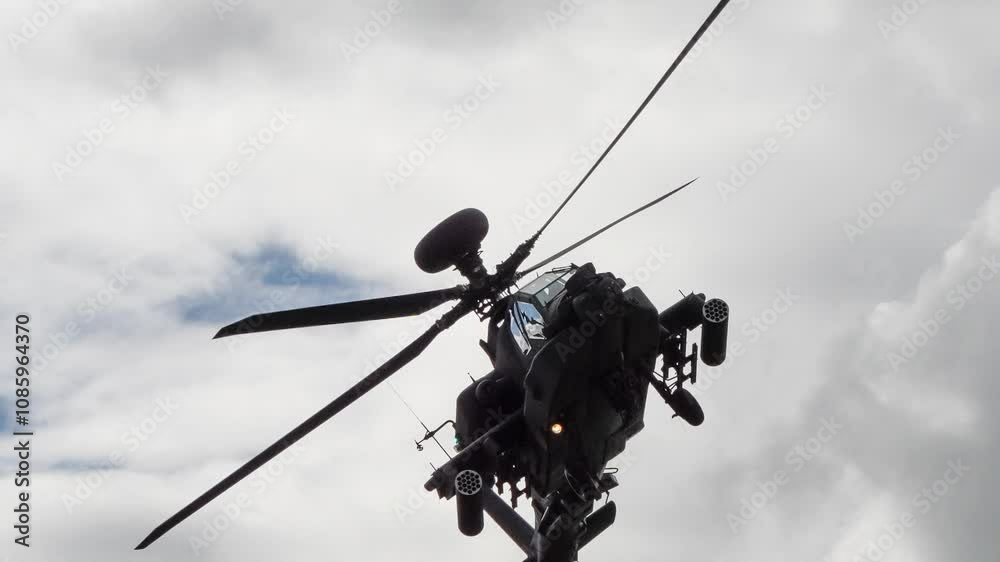 close-up of British army Boeing Apache Attack helicopter longbow gunship AH2 AH64E AH-64E ArmyAirCorp banking hard right and flying directly overhead in low level flight close-up of British army Boeing Apache Attack helicopter longbow gunship AH2 AH64E AH-64E ArmyAirCorp banking hard right and flying directly overhead in low level flight