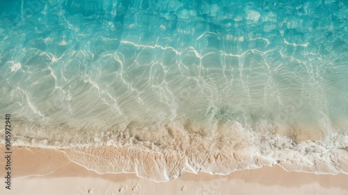 Serene Shoreline: A high-angle shot captures the tranquil meeting of turquoise ocean waves with a sandy beach, highlighting the clear water and soft sand.