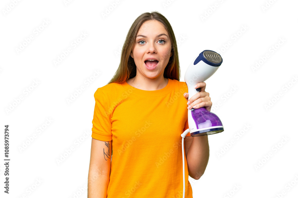 Young blonde woman holding a vertical steam iron over isolated chroma key background with surprise and shocked facial expression Young blonde woman holding a vertical steam iron over isolated chroma key background with surprise and shocked facial expression