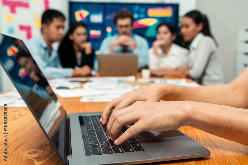 Closeup hand typing keyboard laptop with blurred background of business people using laptop to analyze financial data or data analysis display on screen background. Meticulous Closeup hand typing keyboard laptop with blurred background of business people using laptop to analyze financial data or data analysis display on screen background. Meticulous