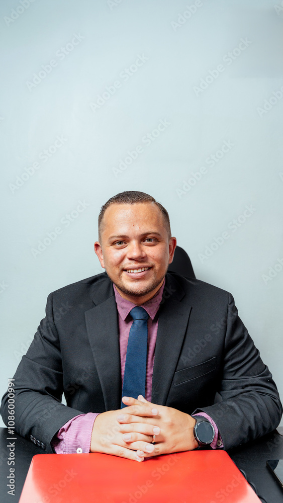 Confident Businessman in Suit Sitting at a Desk in Office Confident Businessman in Suit Sitting at a Desk in Office